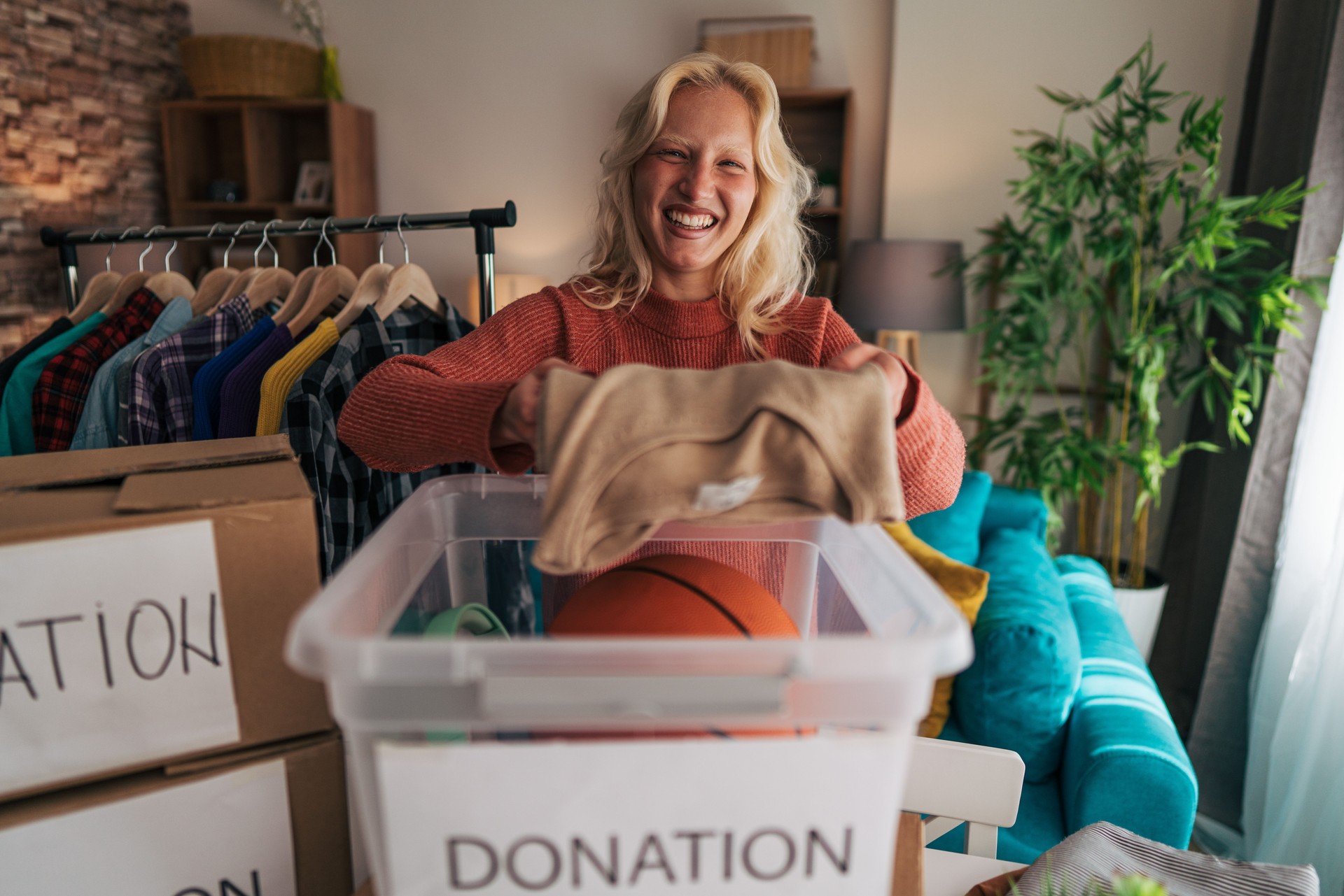 Young woman donating clothes and sporting goods to charity
